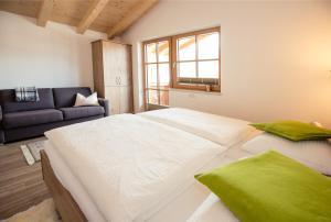Cama blanca grande en habitación con sofá en Appartemets Hauserbauer, en Kaprun