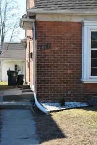 a white hose is attached to a brick house at Stunning Downtown Royal Oak Townhouse (909) in Royal Oak