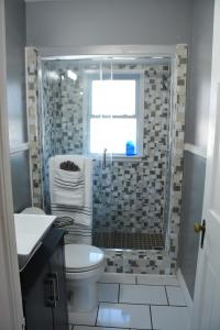 a bathroom with a shower with a toilet and a window at Stunning Downtown Royal Oak Townhouse (909) in Royal Oak