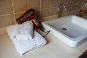 un secador de pelo sentado en una toalla junto a un fregadero en Casa Rustick en Sant Francesc Xavier