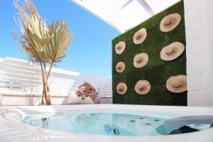 a bathroom with a tub with a plant next to it at Musae Relais & SPA in Polignano a Mare