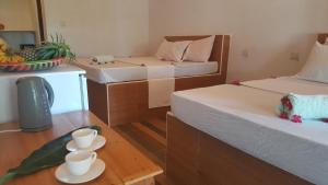 a room with two beds and two cups on a table at BARIDI VILLA in Zanzibar City