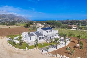 an aerial view of a white house with palm trees at Villa Biancolilla in Castellammare del Golfo