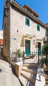un edificio de piedra con puertas verdes y escaleras delante en Apartments Villa Mak en Split