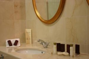 a bathroom with a sink, mirror and bath tub at Grand Hotel Palace in Marsala