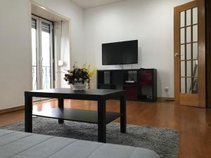 a living room with a black coffee table and a tv at Arroios 169 in Lisbon
