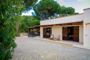 a house with a patio and trees in the background at Villa Madreperla in Marciana