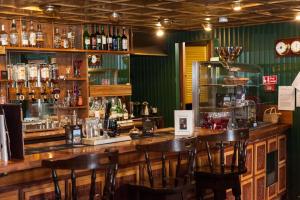 Loch Ness Lodge Hotel في درامنادروشيت: وجود بار بطاولات وكراسي خشبية في المطعم