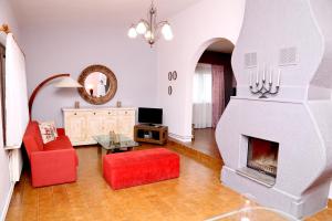 a living room with a fireplace and red chairs at Villa Christie in Keramoti