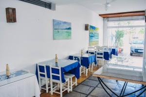 a restaurant with blue tables and chairs in a room at Pousada Kopenhagen Beach in Cabo Frio