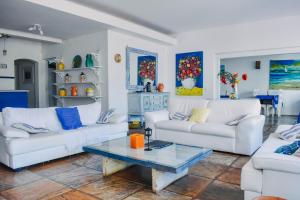 uma sala de estar com dois sofás brancos e uma mesa em Pousada Kopenhagen Beach em Cabo Frio