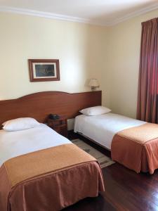 a hotel room with two beds and two lamps at Hotel Ulveira in Oliveira de Frades