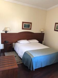a bedroom with a bed and a desk at Hotel Ulveira in Oliveira de Frades