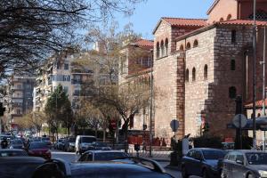 a city street with cars parked in front of a building at White Bottle Superior Apartments in Thessaloniki