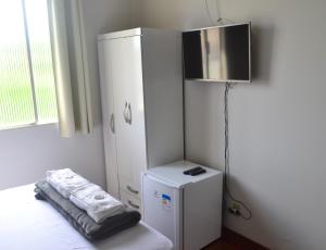 a room with a white cabinet and a small refrigerator at Hospedagem Solar do Rosário in Diamantina