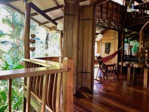 a porch of a house with a hammock in it at Las Ranitas in Puerto Viejo