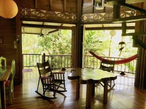 a room with a table and chairs and a balcony at Las Ranitas in Puerto Viejo