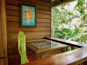 a wooden table and chair in a room with a window at Las Ranitas in Puerto Viejo