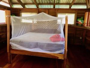 a wooden bed with a canopy in a room at Las Ranitas in Puerto Viejo