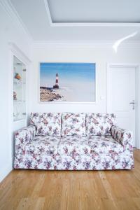 a couch in a living room with a lighthouse at roomsy guest house in Sopot