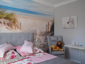 1 dormitorio con 1 cama y una pintura de playa en Kaisers Eck Ferienwohnung en Ahlbeck