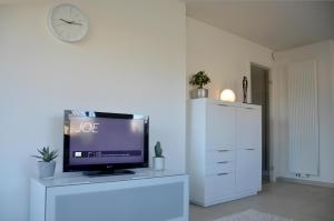 a living room with a tv on a white dresser at DUINLICHT-Oostduinkerke in Oostduinkerke