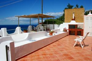 eine Terrasse mit einem Tisch, Stühlen und Meerblick in der Unterkunft Maridea - Vela in Ponza