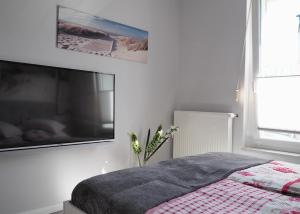 アールベックにあるKaisers Eck Ferienwohnungのベッドと壁にテレビが掛かった寝室