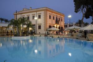 uma grande piscina em frente a um edifício em Grand Hotel Palace em Marsala