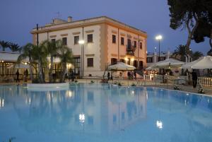 una grande piscina di fronte a un edificio di Grand Hotel Palace a Marsala