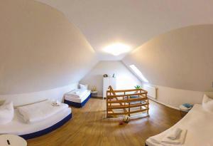 an attic room with two beds and a refrigerator at FerienDüne "Riedensee" in Kühlungsborn +66 photos