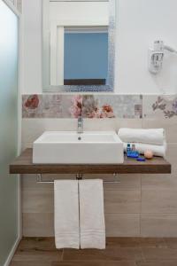 bagno con lavandino e specchio di Hotel Maria Serena a Rimini
