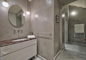 a bathroom with a sink and a mirror and a shower at 10 Strait Street Apartments in Valletta