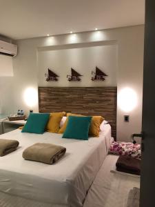 un grande letto bianco con cuscini sopra in una stanza di FLAT 6206F - ANCORAR RESORT a Porto De Galinhas