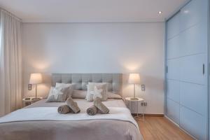 a bedroom with a large white bed with two lamps at Penthouse in Puerto Banus in Marbella