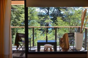 - une vue depuis la fenêtre d'une table et de chaises sur une terrasse couverte dans l'établissement Amarras, à Villa Pehuenia