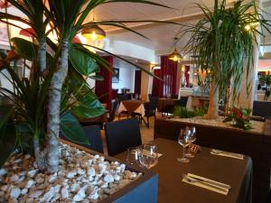 a restaurant with a table with a palm tree in the middle at Le Mazagan in Port-la-Nouvelle