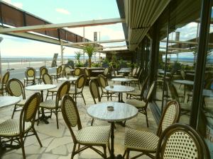 un restaurante vacío con mesas y sillas y el océano en Le Mazagan en Port-la-Nouvelle
