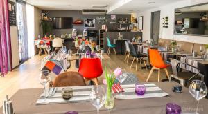a restaurant with tables and chairs in a room at Hotel Restaurant Kyriad Brive Centre in Brive-la-Gaillarde