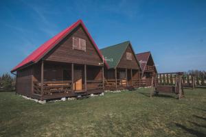 a row of log homes in a field at Trzy Kolory Jezierzany in Jezierzany