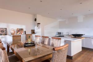 uma sala de jantar com mesa e cadeiras e uma cozinha em Villa exclusiva con espectaculares vistas al Mediterráneo em Cala de Finestrat