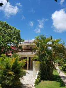 ein Gebäude mit Palmen davor in der Unterkunft Casa dentro de Porto de Galinhas. 04Suítes.01Quarto. in Porto De Galinhas