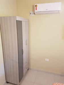 ein weißer Schrank in einem Raum mit Öffnung in der Unterkunft Casa dentro de Porto de Galinhas. 04Suítes.01Quarto. in Porto De Galinhas