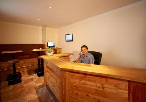 a man sitting at a bar talking on a cell phone at Lärchenhof in Flachau