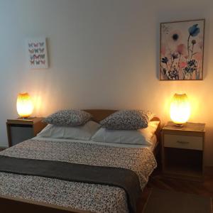 a bedroom with a bed with two lamps on it at Guesthouse Punta Mira - Beachfront in Novalja +31 photos