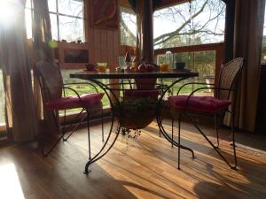mesa y sillas en una habitación con mesa en B&B Kupershof, en Epe
