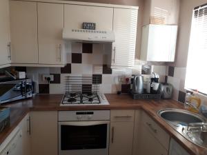 a kitchen with a stove top oven next to a sink at Oldwood Home from Home in Livingston