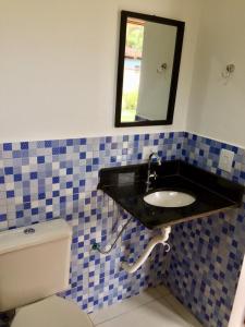 a bathroom with a sink and a toilet at Sunset Maresias- Casas e Chalés C1 in Maresias