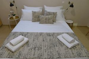 a large bed with white sheets and pillows on it at Maria & Manos Guest House, Agios Onoufrios beach in Agios Onoufrios