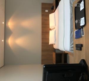 Zimmer mit einem Schreibtisch, einem TV und einem Bett in der Unterkunft Cast Comfort Hotel in Paranaíba + 15 Fotos